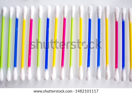 heap of colorful ear sticks on a white abstract background