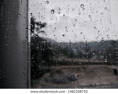 Rain drops at the mirror with blur background of dark day