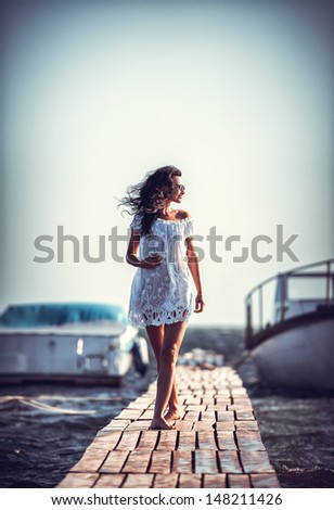 Young woman in a white dress on the beach