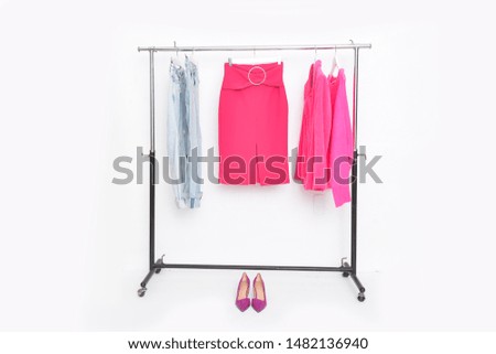 Red skirt with sweater ,coat and two blue jeans on hanger with pink high hell shoes 
