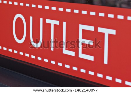 The inscription "outlet" on a red background in a store window. the inscription "outlet" on a red background. sales in stores