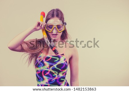 Woman wearing swimsuit with snorkeling mask having fun studio shot, Happy joyful girl dreaming about active summer vacation. Snorkeling swimming concept