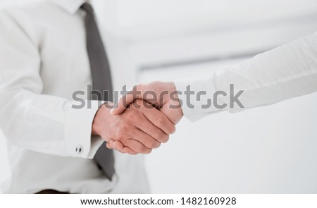 handshake colleagues in a bright office.