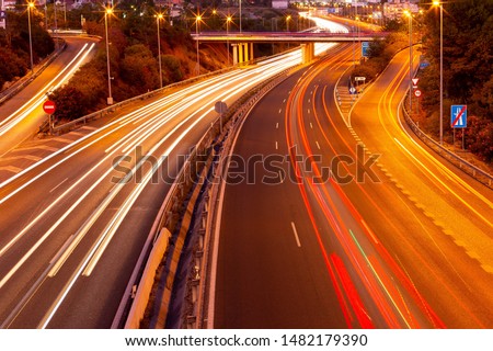 night time spanish highway long exposure motion lapse photography, red and white car light lines on curved motorway system.