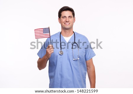 Smiling young male nurse holding American flag 
