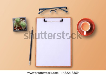 Business concept. Top view with blank clipboard, glasses,pencil,cup of coffee and cactus on orange pastel color background with copy space for text, picture or advertising.