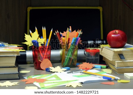 Back to school concept with empty checkered exercise book for homework, pen, pensil, compass, ruler, set squares, protractor, stationary supplies and schoolbooks with apple and autumn leaves