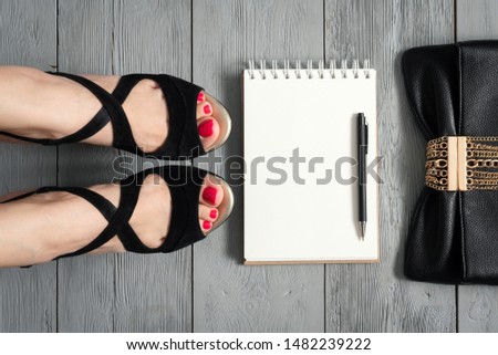 Woman legs in a high heels shoes, clutch bag and a blank page notepad. Women tips. Female tricks mock up. 