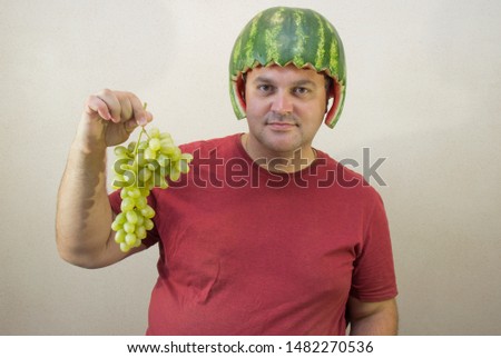 Man wearing a watermelon mask on his head . Funny man with watermelon helmet. water-melon as helmet on head. National Watermelon Day.