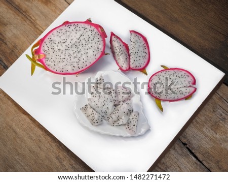 Top view of Pitaya fruit or Dragon fruit isolated on white and wood texture background.