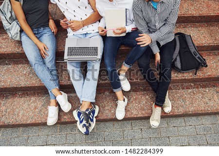 Cropped photo. Top view. Group of young students in casual clothes near university at daytime.
