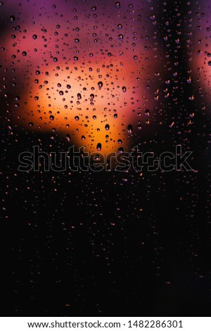 Abstract picture of raindrops on glass at sunset