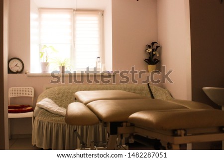 Beauty and body care. Interior of new beauty salon with spa massage table and set of skincare products ready for use. Empty professional dermatologist room waiting for customers
Photo massage room. 
