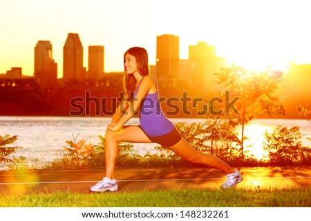 Woman runner stretching legs after running training in sunshine at sunset. Fit female jogger athlete training outside in Montreal, Canada, Quebec.