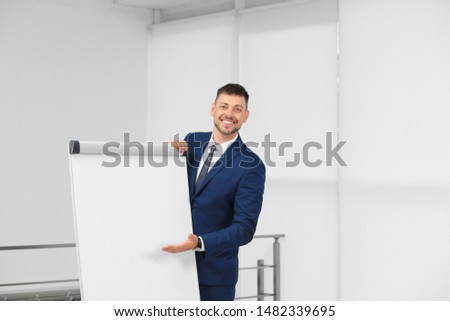 Professional business trainer near flip chart board indoors. Space for text