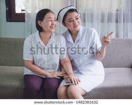 The nurse is caring for the elderly with happiness,Caregiver placed his hand on the hand of senior woman