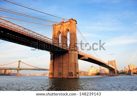 Brooklyn Bridge over East River viewed from New York City Lower Manhattan waterfront at sunset. Royalty-Free Stock Photo #148239143