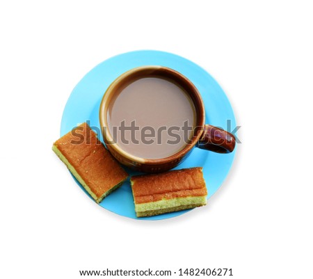 
Ovaltine cups and cakes in a blue plate, top view, isolated on a white background