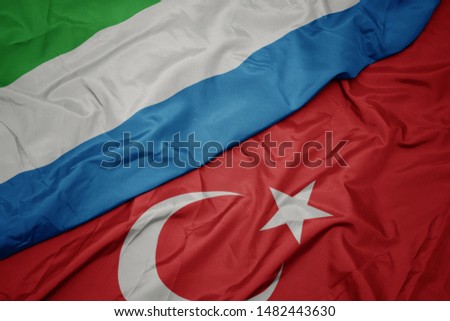 waving colorful flag of turkey and national flag of sierra leone. macro