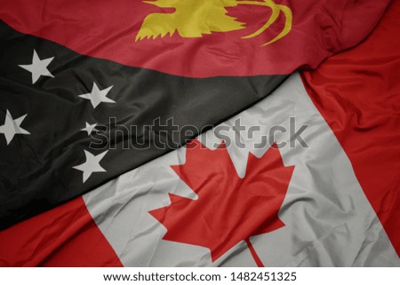 waving colorful flag of canada and national flag of Papua New Guinea. macro