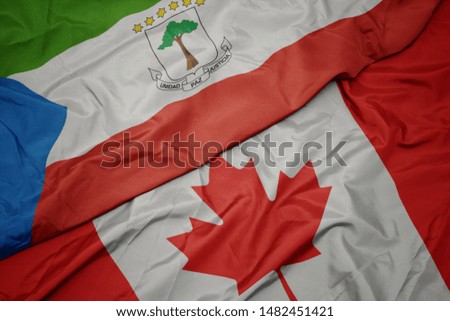 waving colorful flag of canada and national flag of equatorial guinea. macro