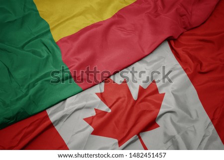 waving colorful flag of canada and national flag of benin. macro