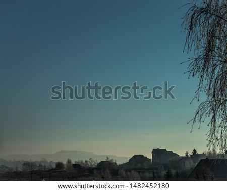 
morning landscape at dawn, view of a frosty winter village with blue cold sky