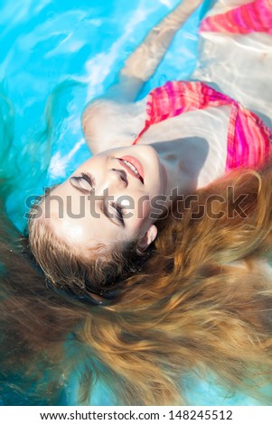 Lovely smile relaxing woman floating on a spa's swimming pool