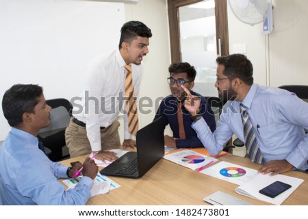 Angry businessman threatening his colleague in office meeting Royalty-Free Stock Photo #1482473801