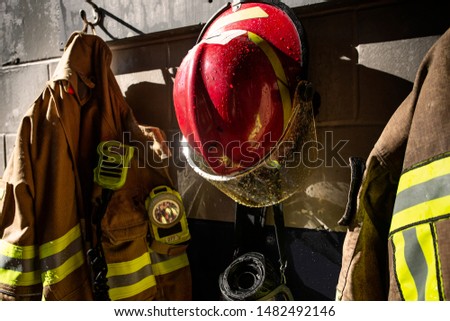Firefighter protection clothes and helmet hanging in the fire station
