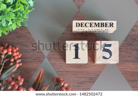 December 15. Date of December month. Number Cube with a flower and leaves on Diamond wood table for the background