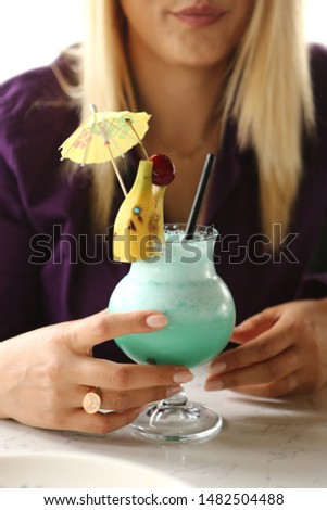 Woman hand holding glass of cocktails. Close up shot of alcoholic drink