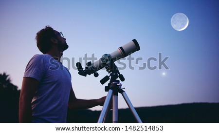 Astronomer with a telescope watching at the stars and Moon.  Royalty-Free Stock Photo #1482514853