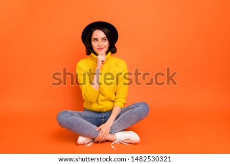 Full length body size photo of cunning pondering girl planning to prank someone while isolated with orange background