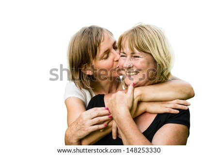 Portrait of happy senior mother kissed by her adult daughter - isolated on white