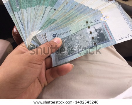 Hand holding Ringgit Malaysia. Bank note
