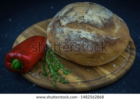 Bread, pepper and thyme, presented on a wooden tray