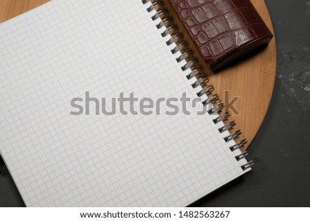 Checkered notebook on a round wooden tray