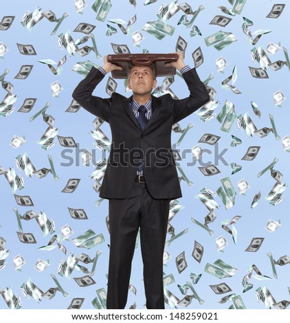 Surprised businessman and flying dollar banknotes against blue sky