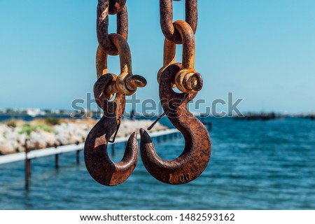 Two Rusty Iron Hooks on the chains in the dock Royalty-Free Stock Photo #1482593162