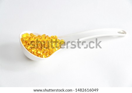 Fish oil capsules in a spoon on white background