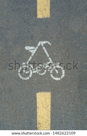 White Bicycle sign on the asphalt road with the yellow stripe close up