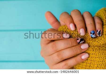 luxury sort of pink  manicure on the blue background. cozy autumn nails. place fo text. Royalty-Free Stock Photo #1482646001