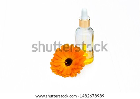 medicinal plant extract, skin care serum with calendula in a glass bottle with a pipette on a white background, isolate, copy space. beauty concept. homeopathic