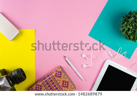 Flat lay of laptop, earphones, digital gadget, modern concept on soft pink background with copy space