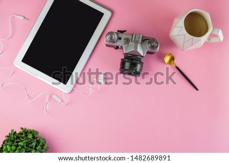 Flat lay of laptop, earphones, digital gadget, modern concept on soft pink background with copy space