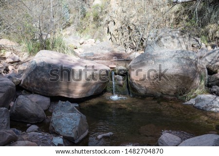 Stone boulder creek river with waterfall in Andean pine forest, Bolivia, Chuquisaca, Cajamarca