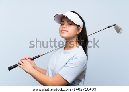 Young golfer Asian girl over isolated blue background