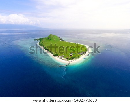 Small tropical island with white green savannah and sandy beach. Beautiful Kenawa island view from above. Nature of the Indonesia Islands