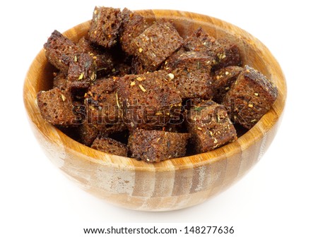 Spicy Whole Grain Bread Croutons with Garlic and Herbs in Wooden Bowl isolated on white background